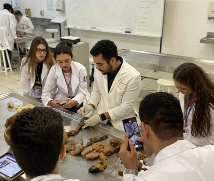 Dr. Jônatas em aula prática de anatomia, demonstrando peças anatômicas para estudantes