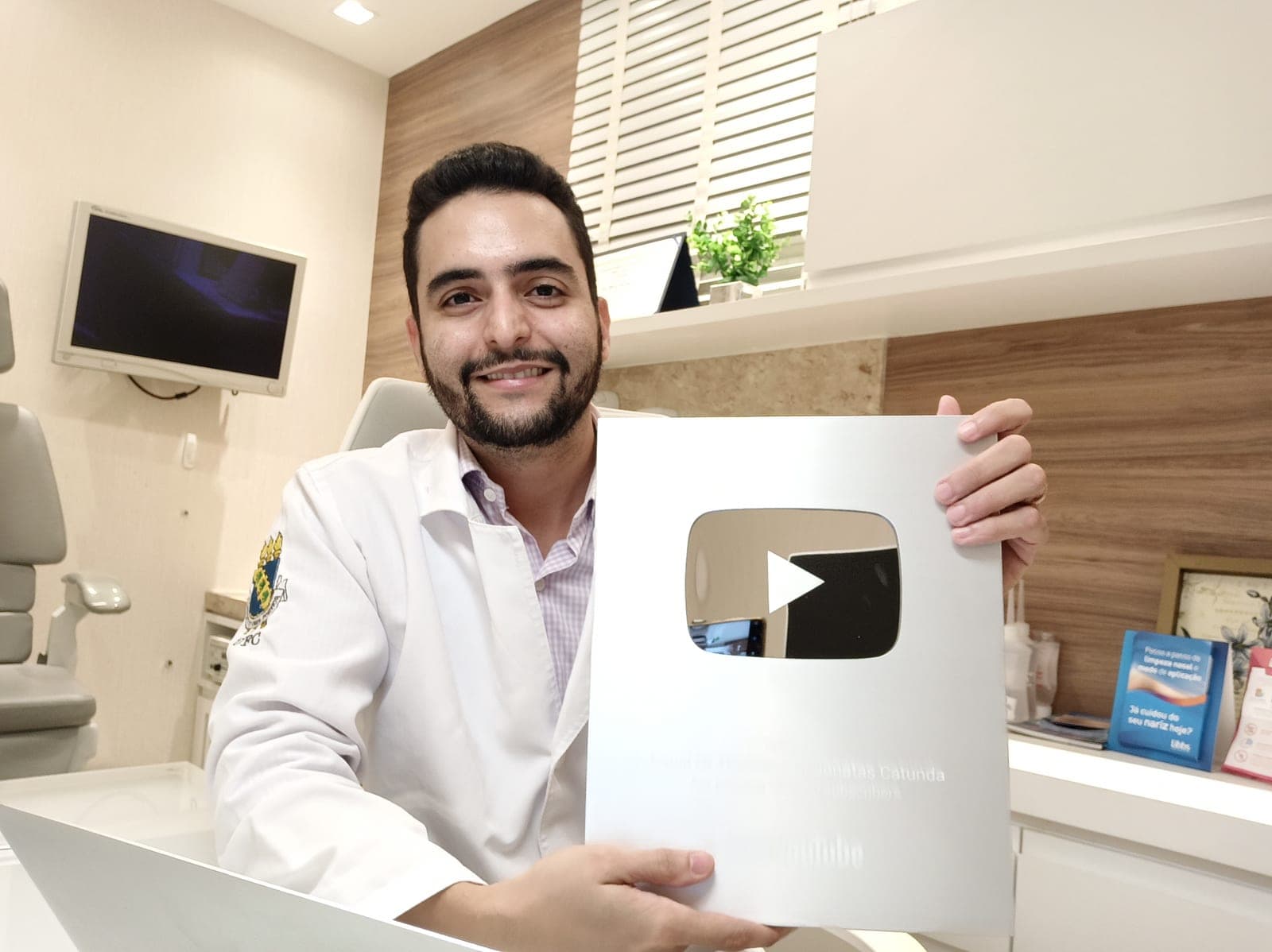 Dr. Jônatas segurando a placa de 100 mil inscritos do YouTube em 2019