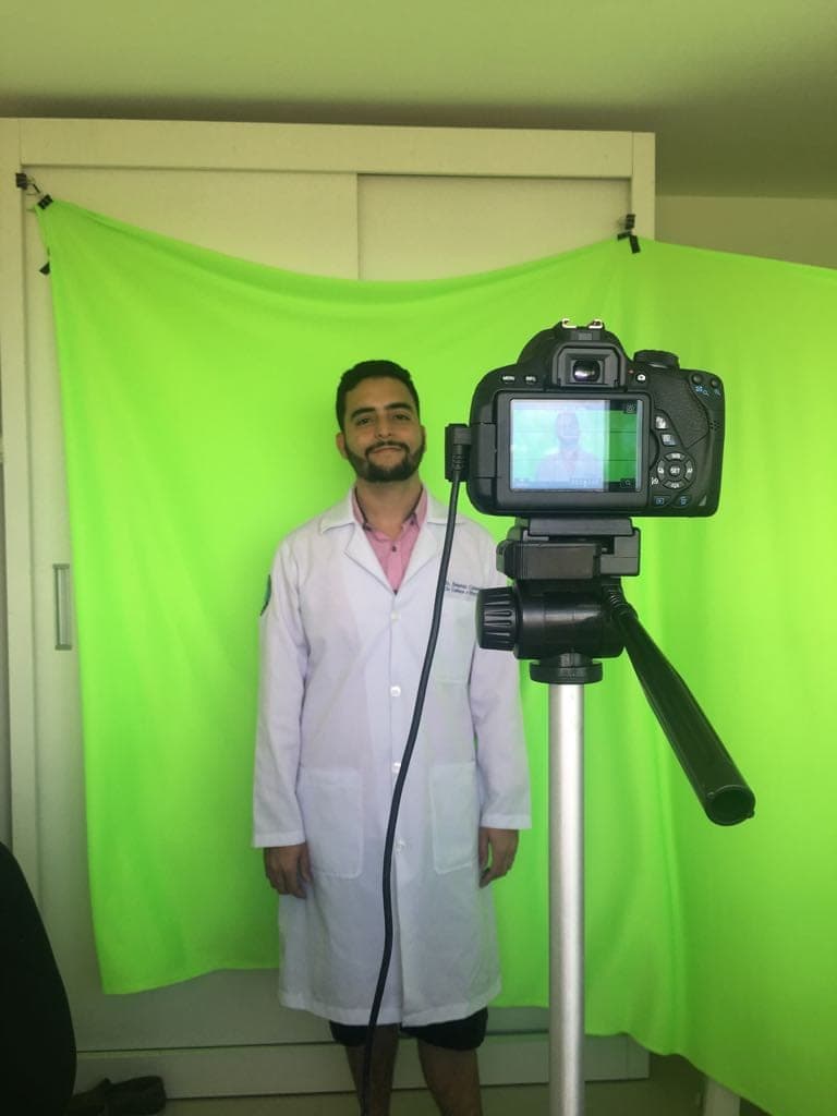 Dr. Jônatas gravando o primeiro vídeo do canal em 2018, diante de um fundo verde improvisado